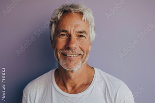 Portrait of a senior man with grey hair and a white t-shirt.