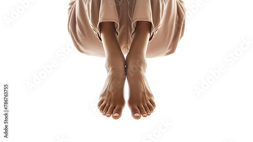 Bare feet crossed at the ankles, with a draped brown fabric, on a white background. photo