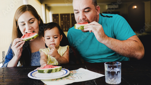 Latin family eating at home. Father, mother and baby daughter dining together. Family concept