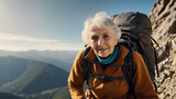 An elderly woman in climbing clothing with sunlight in the background climbing a mountain