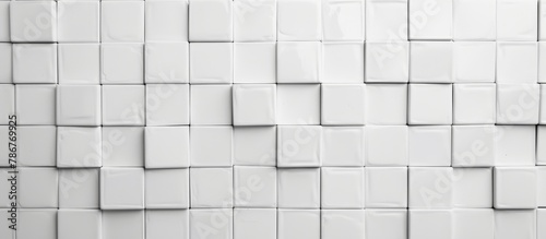 Close up view of a white tiled wall featuring a multitude of square tiles in a grid pattern, creating a clean and uniform surface