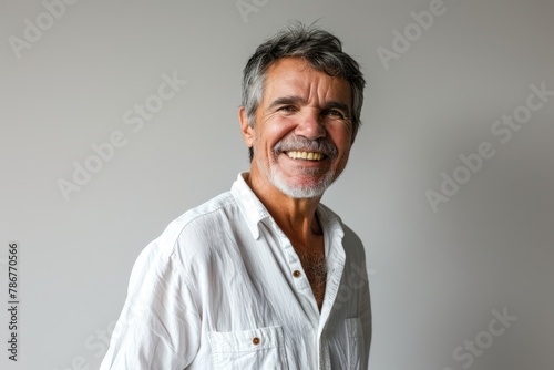 Portrait of a senior man with white shirt on grey background. © Chacmool