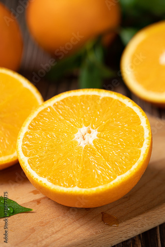 Fototapeta Naklejka Na Ścianę i Meble -  Fresh orange with cut in half on wooden table.