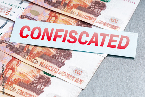 Russian ruble money and list with word CONFISCATED. Arrest, confiscation of financial assrts of Russia.