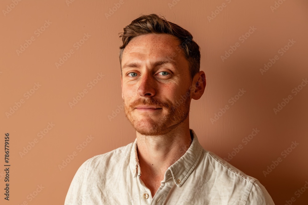 Portrait of a red-haired man in a white shirt on a brown background Portrait of a red-haired man in a white shirt on a brown background