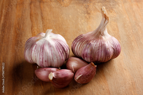 Close Up Raw, Fresh Garlic Cloves and Bulbs on Rustic Wooden Table