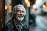 Portrait of a senior man with gray hair and beard in a leather jacket on a city street