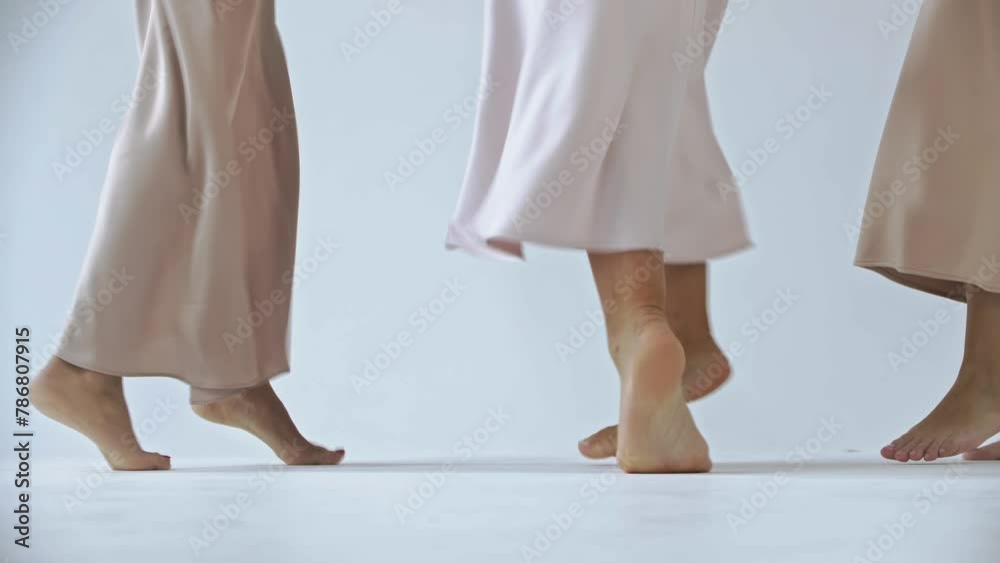 Three pairs of female feet dance barefoot on a snow-white cyclorama backdrop in the studio. Close up. Slow motion. 4k Three pairs of female feet dance barefoot on a snow-white cyclorama backdrop in the studio. Close up. Slow motion. 4k