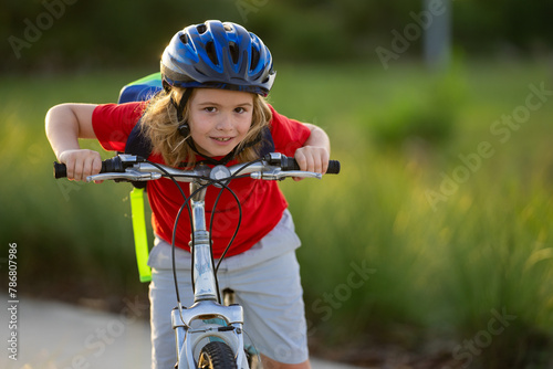 Little kid boy ride a bike in the park. Kid cycling on bicycle. Happy smiling child in helmet riding a bike. Boy start to ride a bicycle. Sporty kid bike riding on bikeway. Kids bike.