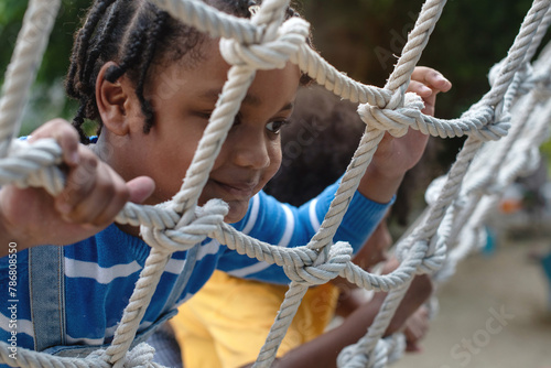Close up, African child boy climbing a rope ladder, selective focus photo
