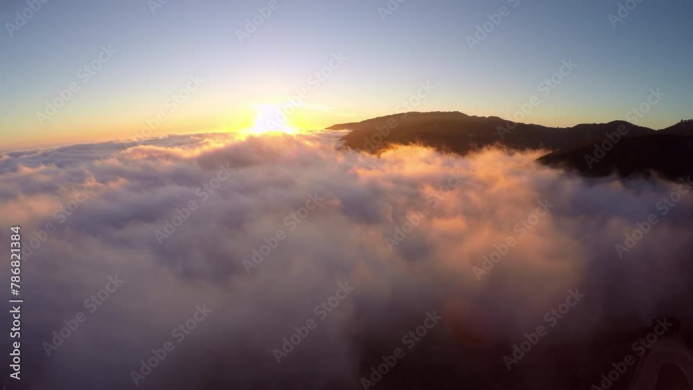 Aerial Backward Scenic View Of Winding Road On Mountains In Fluffy Cloudscape During Sunset - Los Angeles, California Aerial Backward Scenic View Of Winding Road On Mountains In Fluffy Cloudscape During Sunset - Los Angeles, California