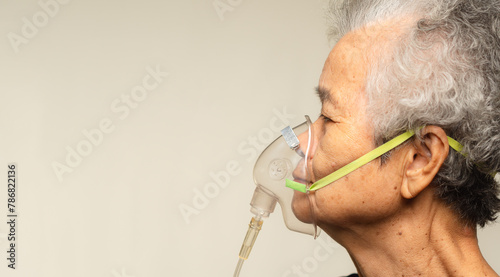 An elderly woman using an oxygen mask.