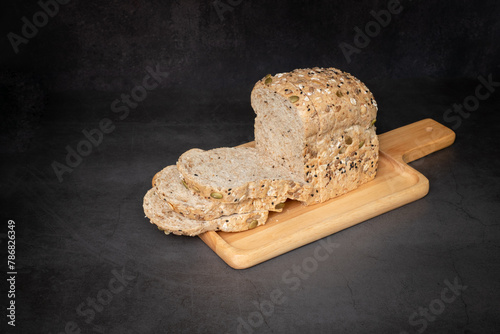 Stack grain loaf bread on a tray with black background