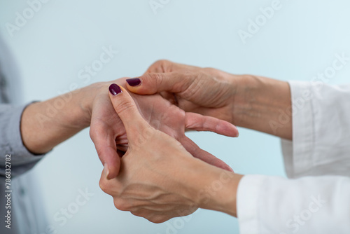 A medical professional conducts a comprehensive Carpal Tunnel Syndrome test with a senior woman, assessing wrist function and nerve health