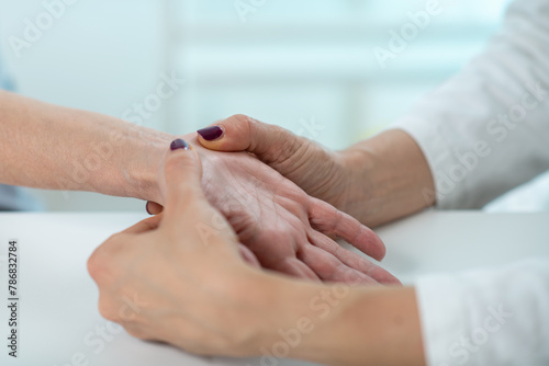 Close up examination of a senior womans wrist to diagnose Carpal Tunnel Syndrome, a common condition causing hand discomfort