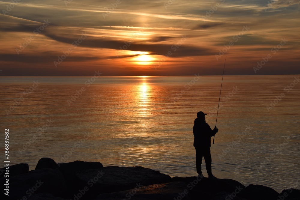 Fisherman at dawn on the rocks