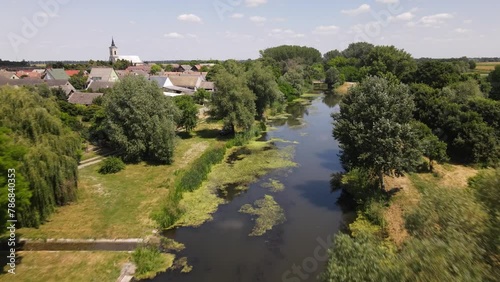 Flyover about stagnant stream running through village in Batya, Hungary. photo