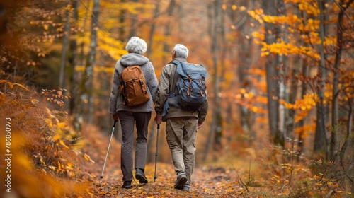 Elderly couple hiking through a forest trail, enjoying the autumn colors