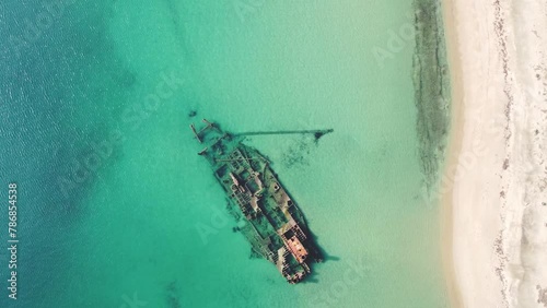 Epanomi Shipwreck: Sunken Transport Ship in Thessaloniki Greece's Turquoise Blue Waters. Run Aground on a Sandbar, Abandoned Ship Submerged on Sea Floor. Birds Eye View Cinematic Drone Shot Close-up. photo