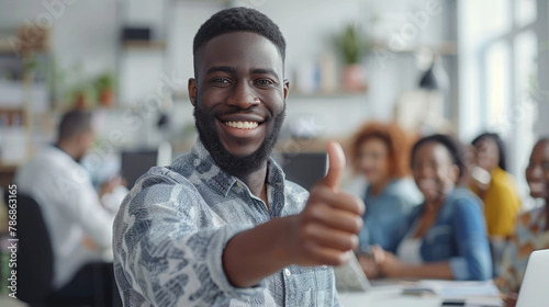 Portrait of happy African American business leader in casual shirt giving thumbs up, group of diverse office workers are in blurry background photo