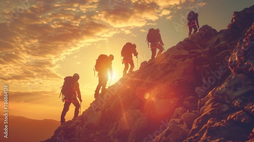 Teamwork: A group of silhouetted figures climbing a mountain together