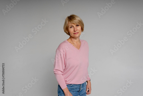 An adult beautiful woman standing on white font lookig confident happy mature business concept  photo