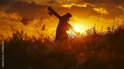 Silhouette of Jesus carrying the cross during sunset