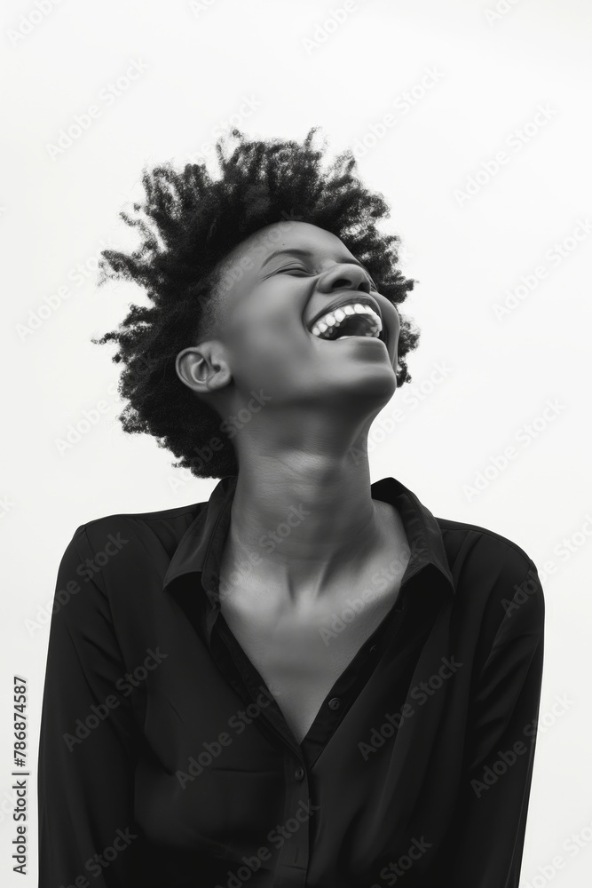 Black and white portrait of a joyful young woman laughing with her head tilted back.