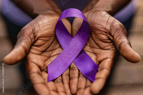 Close up of elderly black man's hands holding large purple Alzheimer disease awareness ribbon