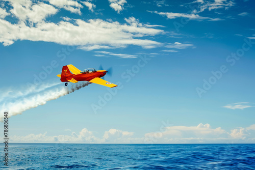 A small red plane is flying over the ocean