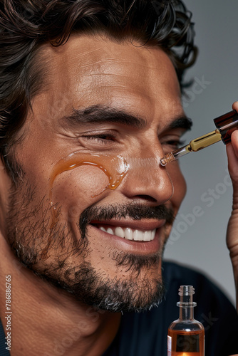 A man is smiling as he holds a bottle of liquid and oil, applying them to his face © Hryhor Denys