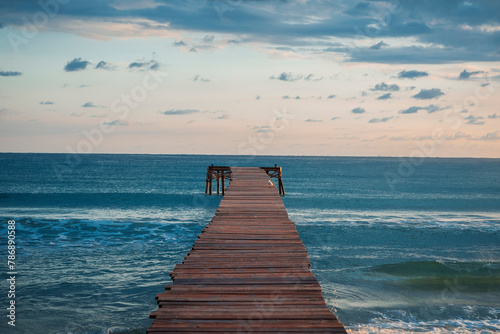 tranquil scenery of a lonely dock at Playa de Muro Mallorca Spain in the morning  photo