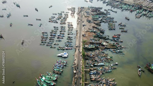 The bustling fish port of Muncar lies a silent crisis: water pollution threatens its livelihood. Witness the struggle for sustainability. 4k aerial, drone footage photo