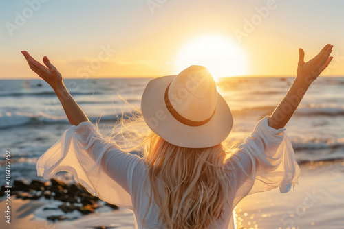 Radiant Blonde Woman Celebrating the Day's End on the Seashore photo