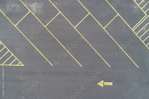 Asphalt parking lot with yellow lines an leftpointing arrow