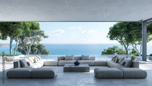 a large modern living room with grey sofas and white walls, overlooking the sea in an island. The windows show trees on one side of the wall and ocean in front.