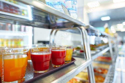 Colorful Array of Fruit Juice Cups on a Serving Cart in a Cafeteria © fotofabrika