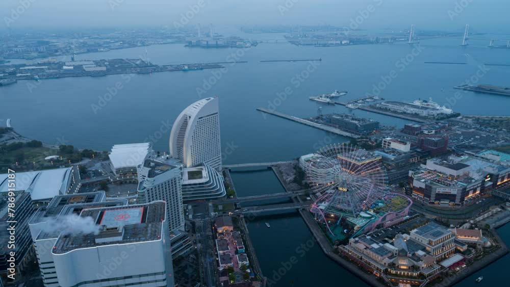 Time Lapse video Aerial view of Yokohama landmark Minato Mirai area represents the transition from day to night, and the city lights are turned on, along with the lights of transportation. 4K Res