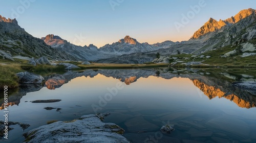Calm mountain lake reflecting the sunset in the mountains © Ammar