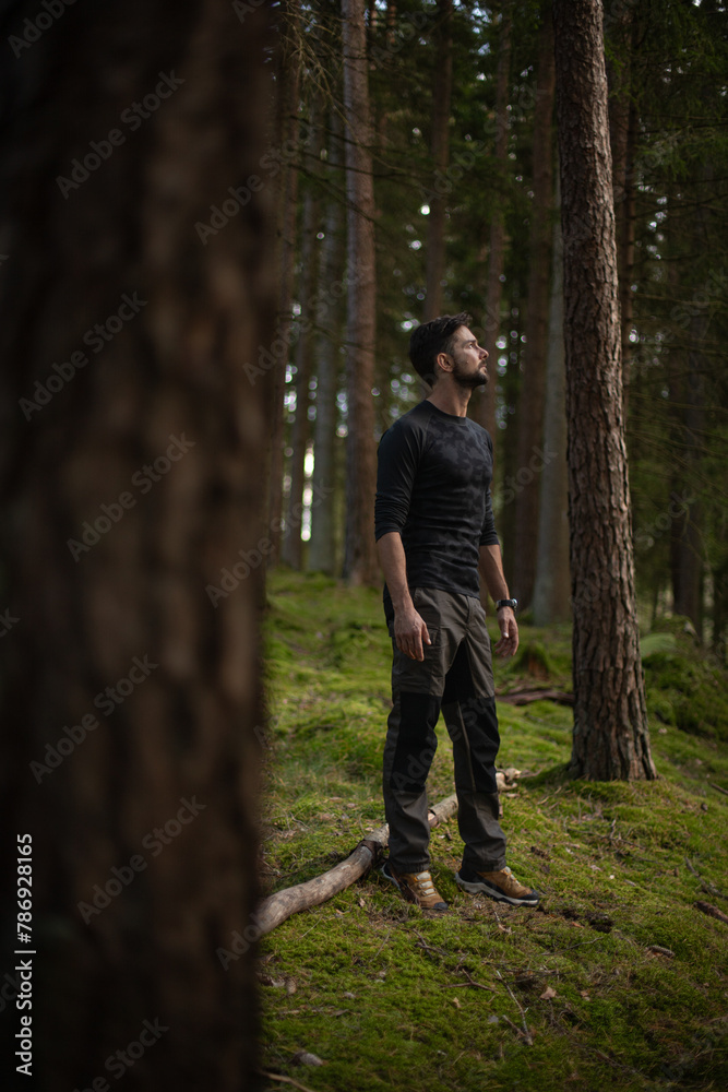 Man standing in nature in the middle of moss and pines.jpg Man standing in nature in the middle of moss and pines.jpg