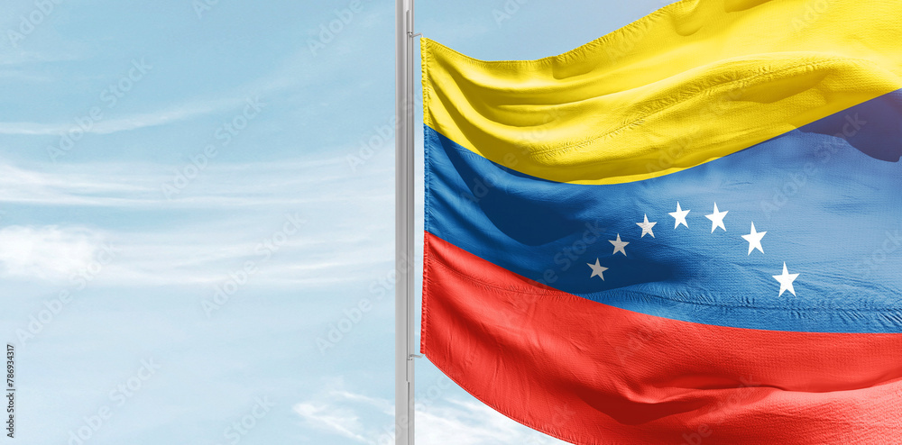 Venezuela national flag with mast at light blue sky. - obrazy, fototapety, plakaty 
