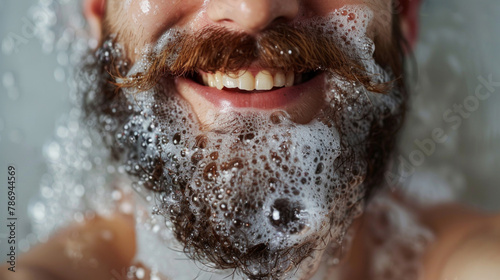 Smile, beard and man in bath with bubbles for clean, health and skincare routine with body hygiene. Foam, mouth and closeup of happy male person with facial hair washing in water for wellness at home photo