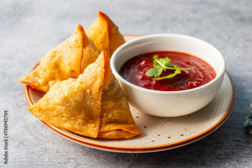 selective focus Samosa, Spiced potato-filled pastry, crispy, Savory, popular Indian snack serve with tomato sauce.  photo