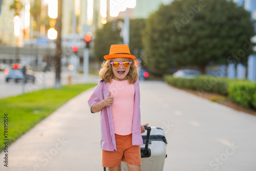 Travelling concept. Portrait of child traveler with travel bag. Little tourist with suitcase ready to travelling. © Volodymyr