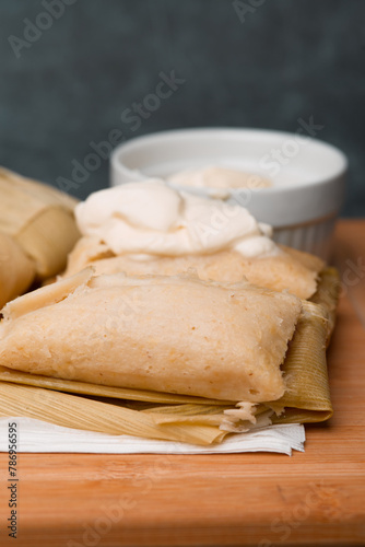 Central American tradition: savory tamales wrapped in corn leaves, served with creamy goodness, a taste of El Salvador