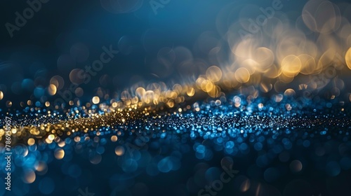 Blue and gold glittering bokeh lights scattered across a dark backdrop, giving a feeling of celebration.