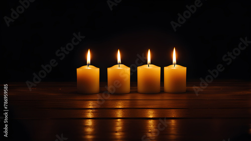 Candles on a wooden table in the dark. Black background.