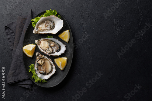 Fresh oysters with lemon on plate © karandaev