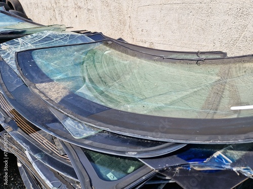 A pile of broken windshields and old car tires