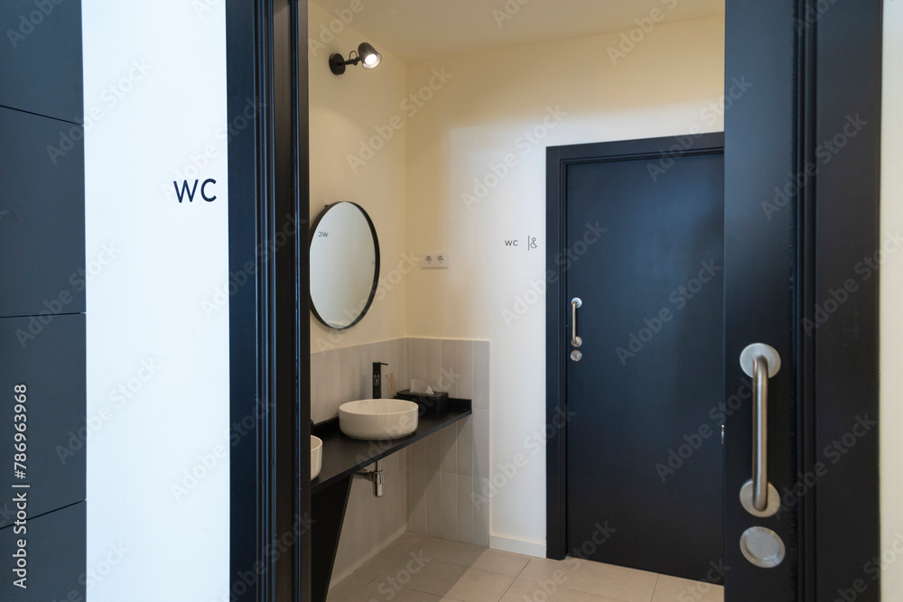 Modern restroom interior with sleek design and round mirror. Modern restroom interior with sleek design and round mirror.